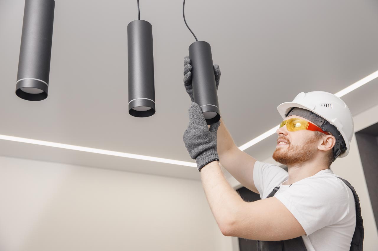 Electrician installing pendant ceiling lights