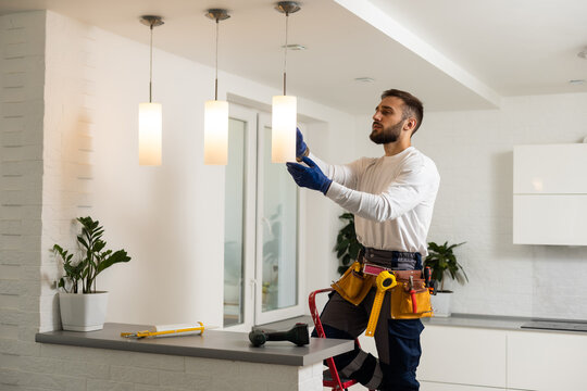 Electrician installing kitchen pendant lights