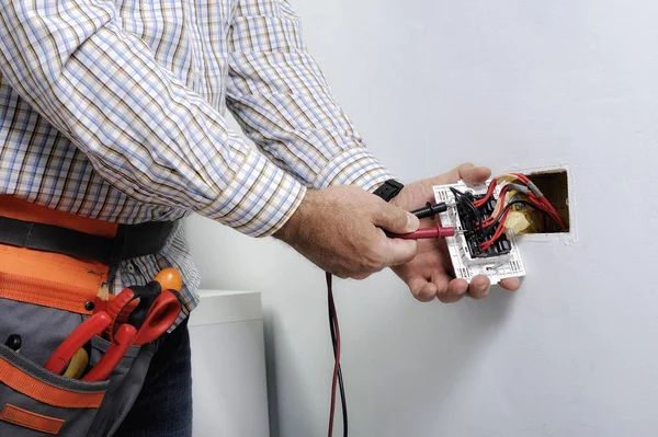 Electrician repairing wall outlet