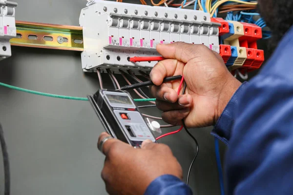 Electrician testing with digital multimeter