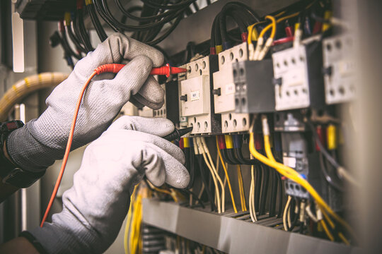 Electrician testing circuit breaker panel